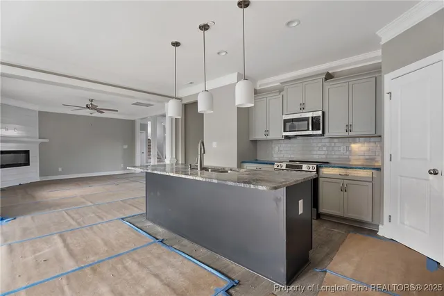 a kitchen with stainless steel appliances granite countertop a stove a sink and a refrigerator