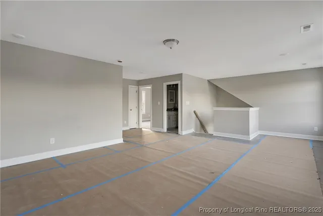 a view of an empty room with wooden floor and cabinet