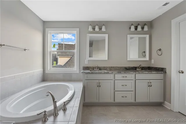 a bathroom with a granite countertop sink mirror and window