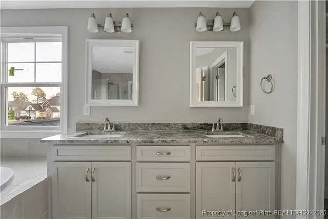a bathroom with a granite countertop tub sink and mirror