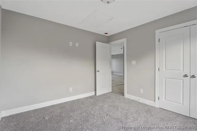 an empty room with windows and closet