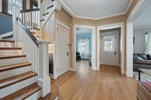 a view of a hallway with wooden floor and stairs