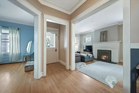 a view of a livingroom with wooden floor and a fireplace