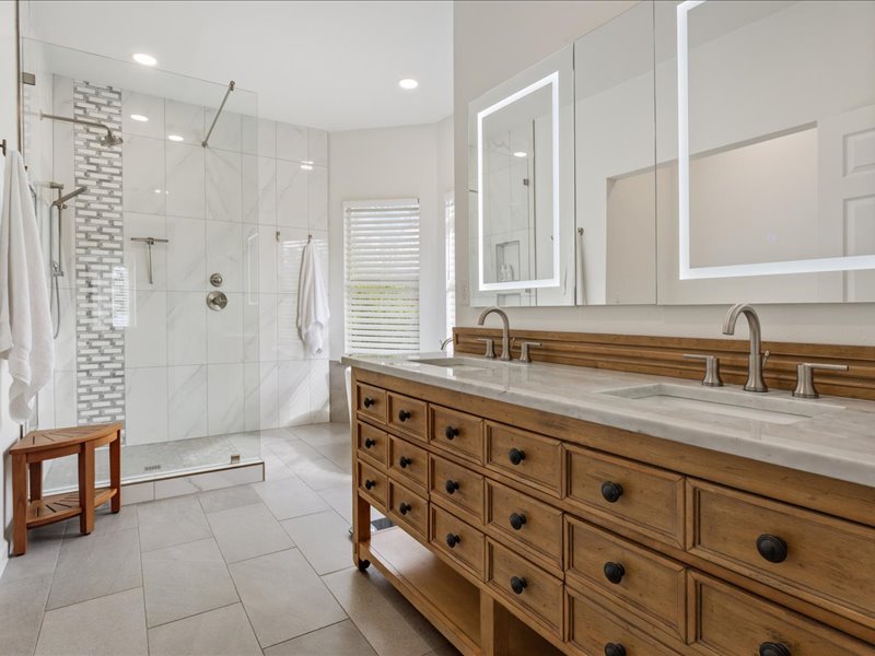 1205 South Main Street Georgetown, TX 78626 - Photo 16 of 35 a bathroom with a granite countertop sink a mirror and a shower