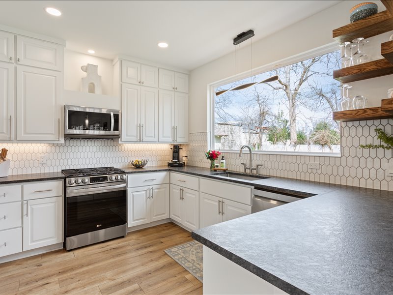 1205 South Main Street Georgetown, TX 78626 - Photo 8 of 35 a kitchen with stainless steel appliances granite countertop a stove a sink and a microwave