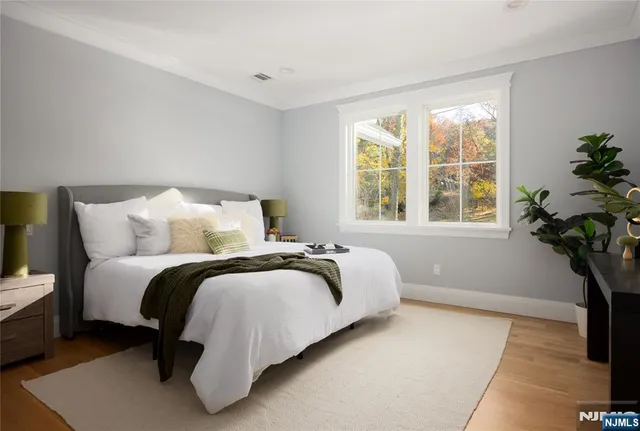 a bedroom with a bed lamp and a potted plant
