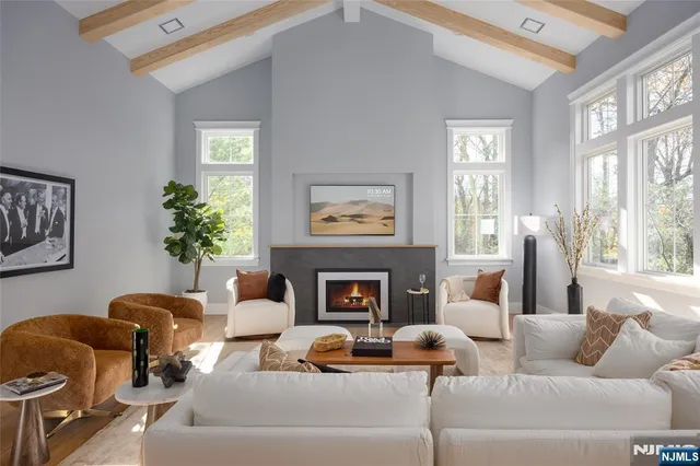 a living room with furniture fireplace and a large window