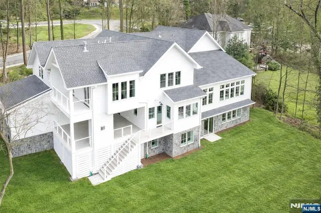 a kitchen with stainless steel appliances granite countertop a kitchen island a stove a sink a dining table and chairs with wooden floor