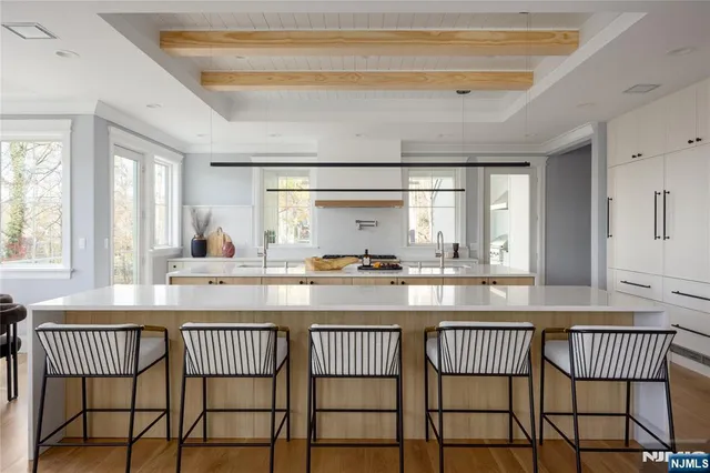 a kitchen with a dining table chairs and white cabinets
