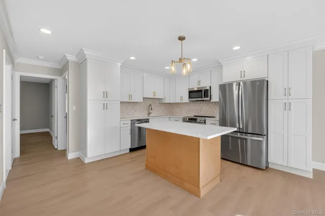 a kitchen with stainless steel appliances granite countertop a refrigerator and a stove top oven
