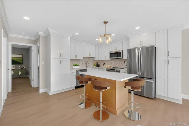 a kitchen with kitchen island wooden cabinets and refrigerator