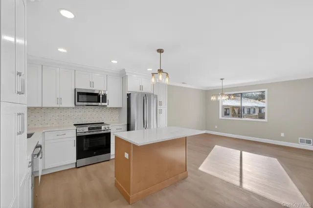 a kitchen with stainless steel appliances granite countertop a refrigerator and a stove top oven