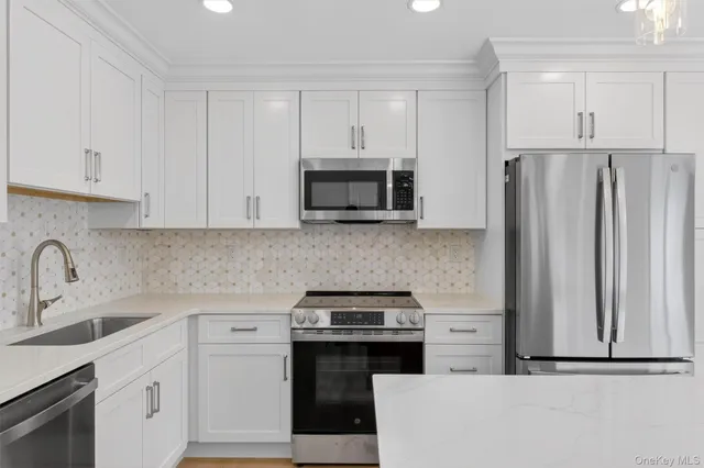 a kitchen with appliances a sink and cabinets