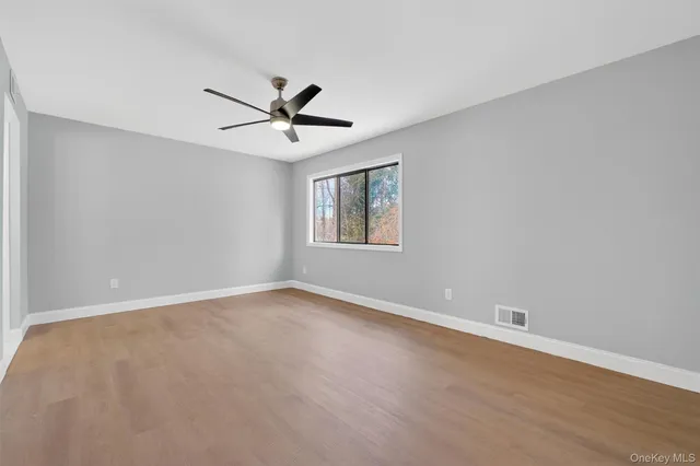 a view of a big room with wooden floor and windows