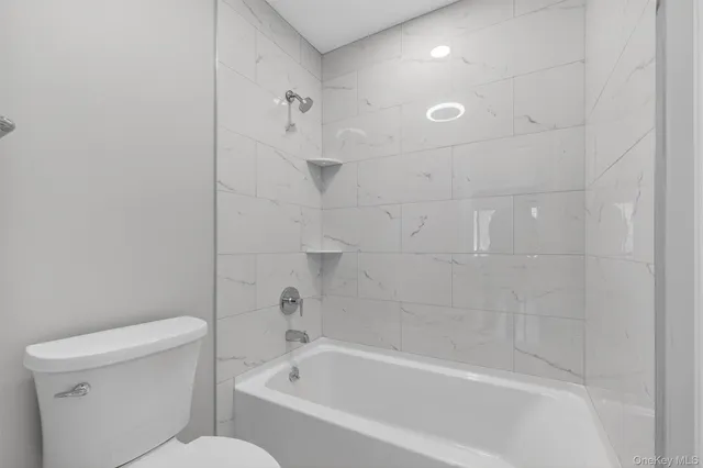 a white bath tub sitting next to a toilet