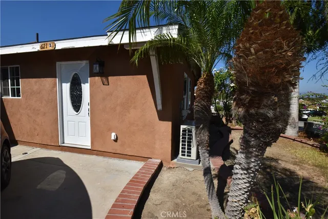 a backyard of a house with table and chairs under an umbrella