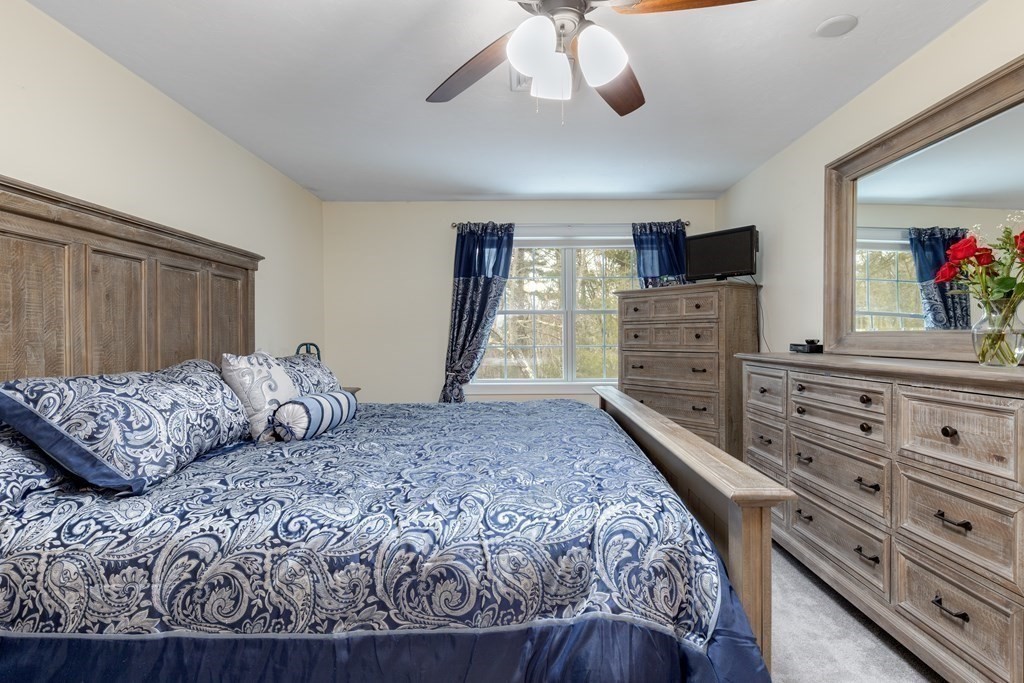 2 Charles Ridge Road, Unit D Littleton, MA 01460 - Photo 16 of 30 a bedroom with a large bed and a flat screen tv