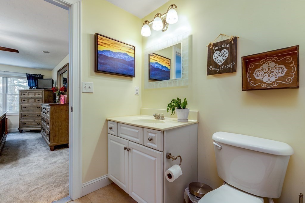 2 Charles Ridge Road, Unit D Littleton, MA 01460 - Photo 19 of 30 a bathroom with a toilet a sink and a mirror