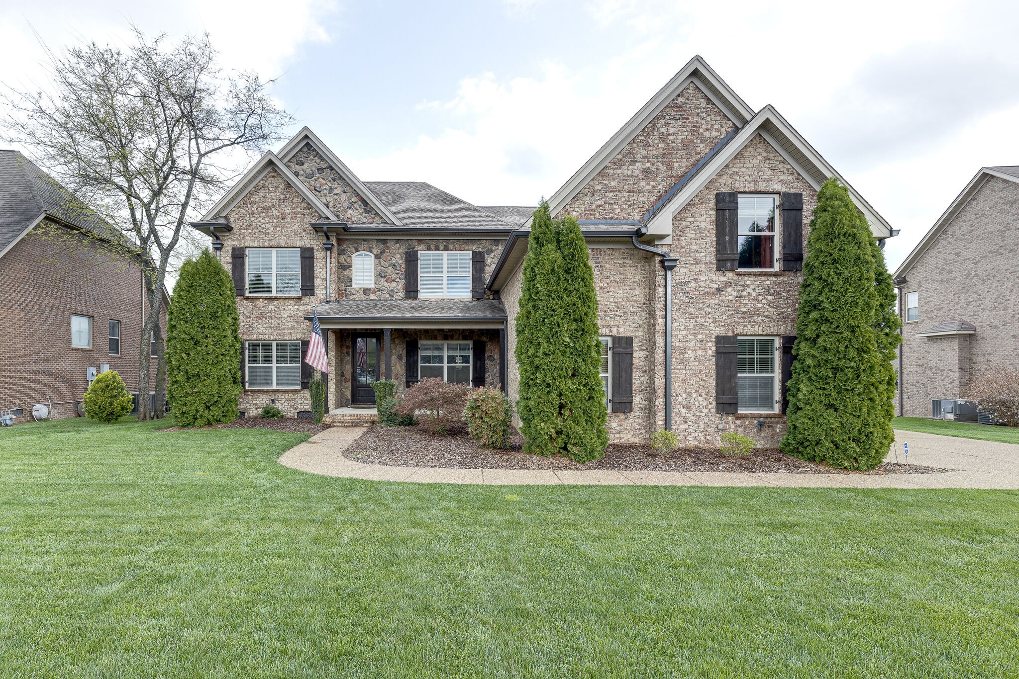 a front view of a house with a garden and yard