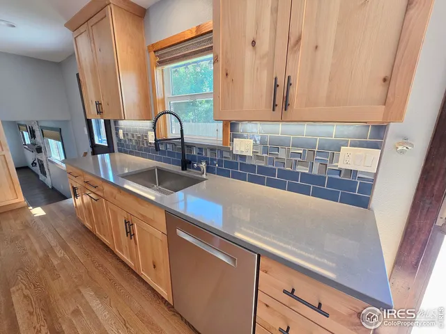 a kitchen with granite countertop a sink and a large window