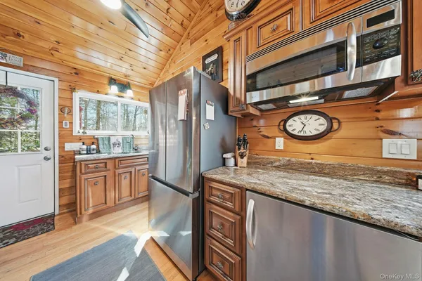 a kitchen with stainless steel appliances granite countertop a sink a stove cabinets and wooden floor