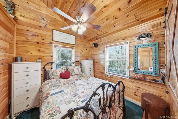 a bedroom with a bed a chandelier and a large window with outer view