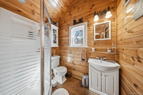 a bathroom with a sink toilet a mirror and shower
