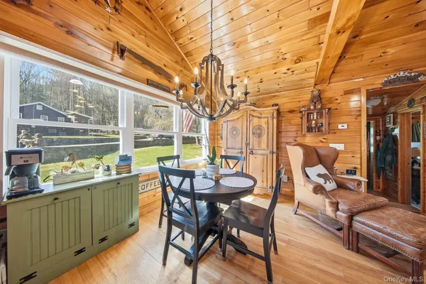 a dining room with furniture and a floor to ceiling window