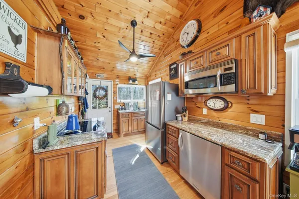 a kitchen with stainless steel appliances granite countertop a stove and a wooden cabinets