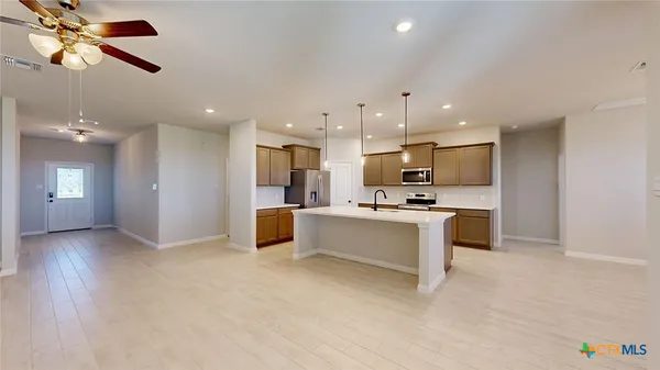 a kitchen with kitchen island a sink stainless steel appliances and white cabinets