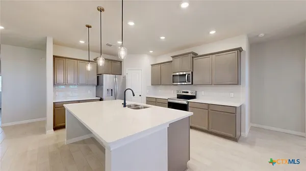a kitchen with a sink stainless steel appliances and white cabinets