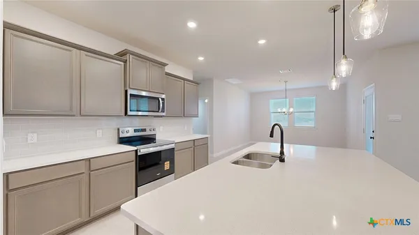 a kitchen with stainless steel appliances a sink stove and refrigerator