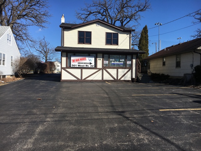 a view of a white house with a large tree
