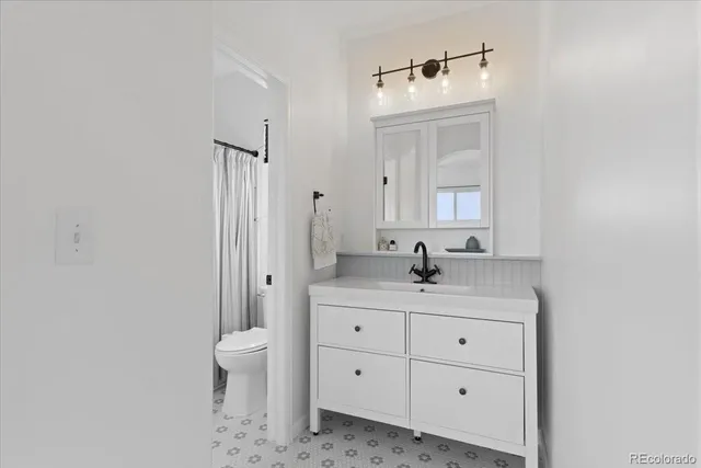 a bathroom with a granite countertop sink a toilet and a mirror