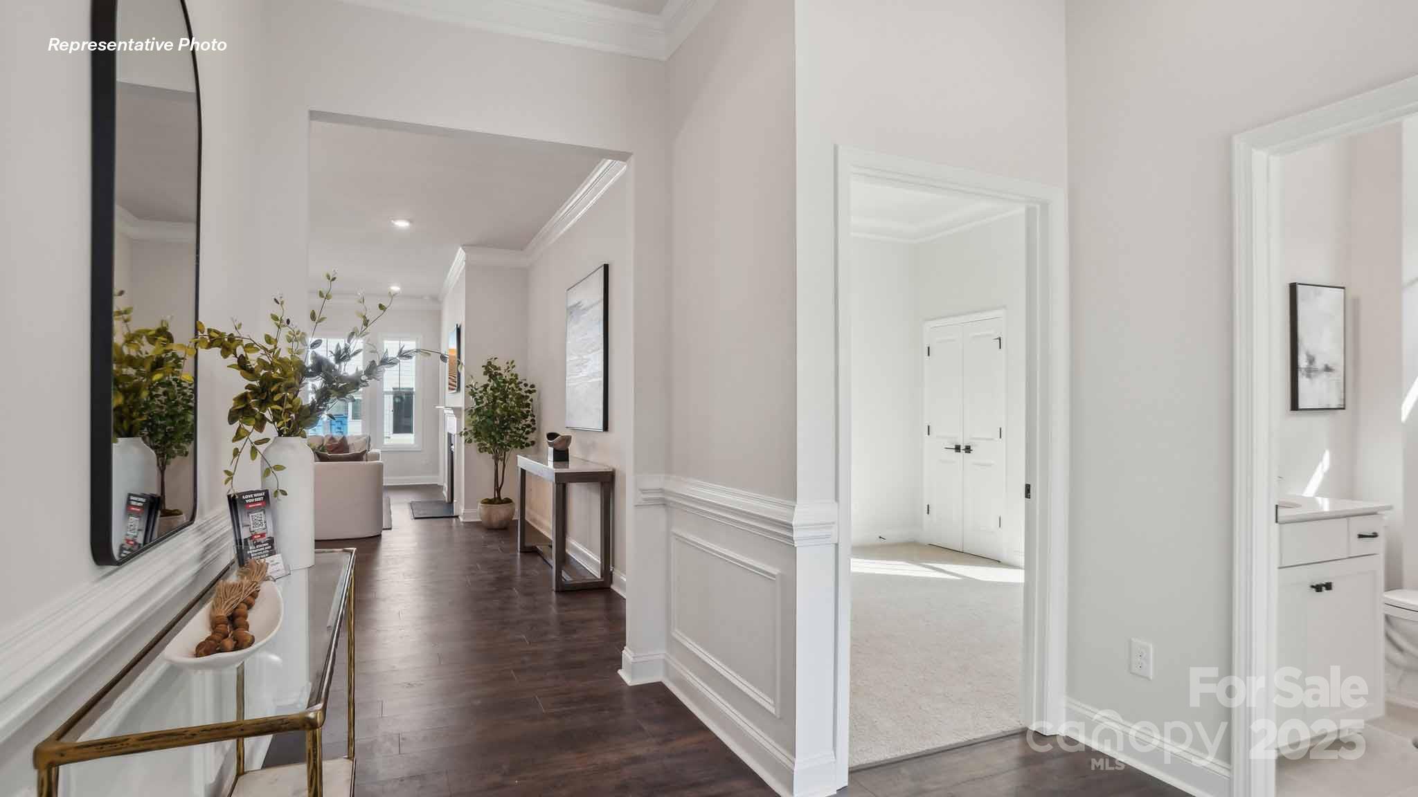 3128 Spring Iris Drive Denver, NC 28037 - Photo 2 of 24 a view of a hallway with wooden floor a flat screen tv and a potted plant