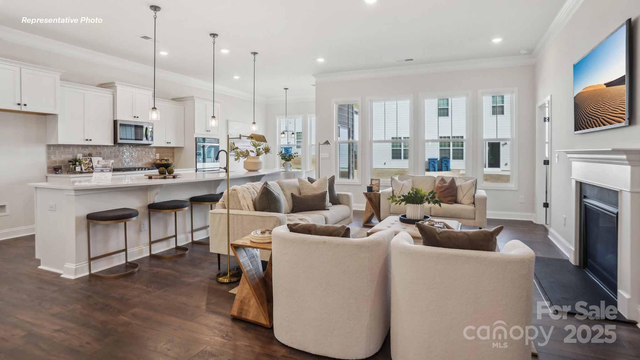 3128 Spring Iris Drive Denver, NC 28037 - Photo 10 of 24 a kitchen with stainless steel appliances kitchen island granite countertop a stove and a view of living room with a flat screen tv