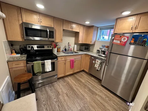a kitchen with granite countertop a refrigerator stove and microwave