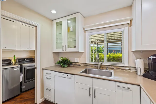 a kitchen with stainless steel appliances a sink a large window and cabinets