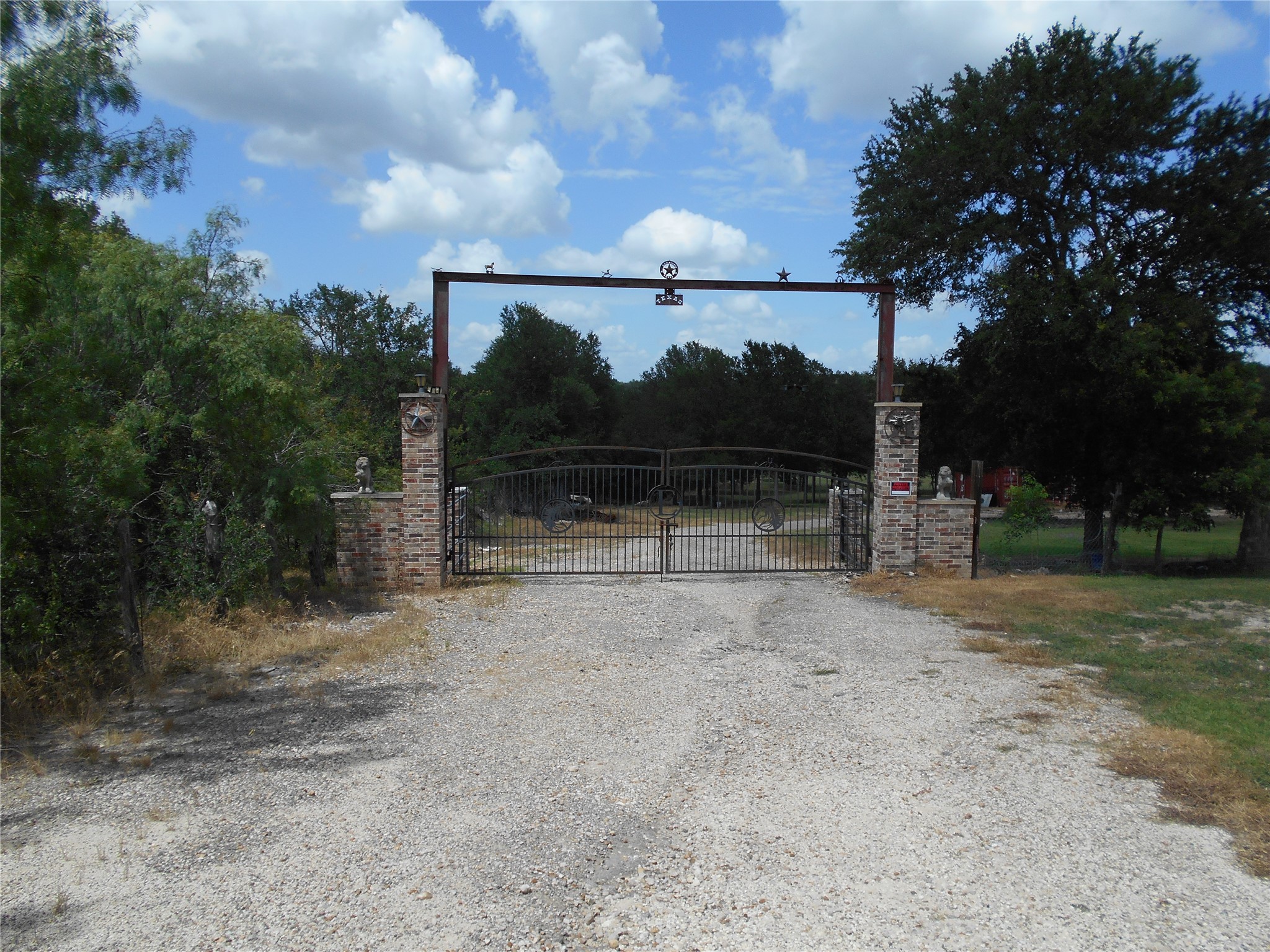 8001 Burleson Manor Road Manor, TX 78653 - Photo 4 of 31 Secure entry to a private property, offering a grand welcome amidst natural surroundings.