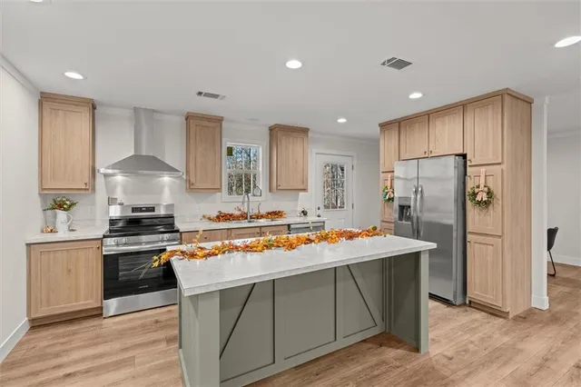 a kitchen with stainless steel appliances granite countertop a sink stove and refrigerator