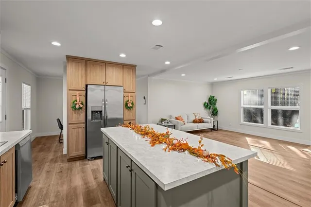 a kitchen with refrigerator and wooden floor