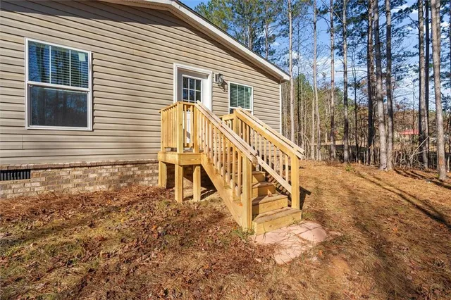 a view of house with a yard and wooden fence