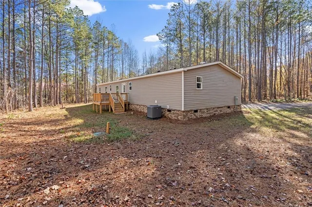 a view of backyard with wooden fence and large trees