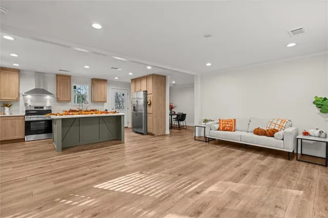 a view of kitchen with kitchen island stainless steel appliances wooden cabinets and counter space