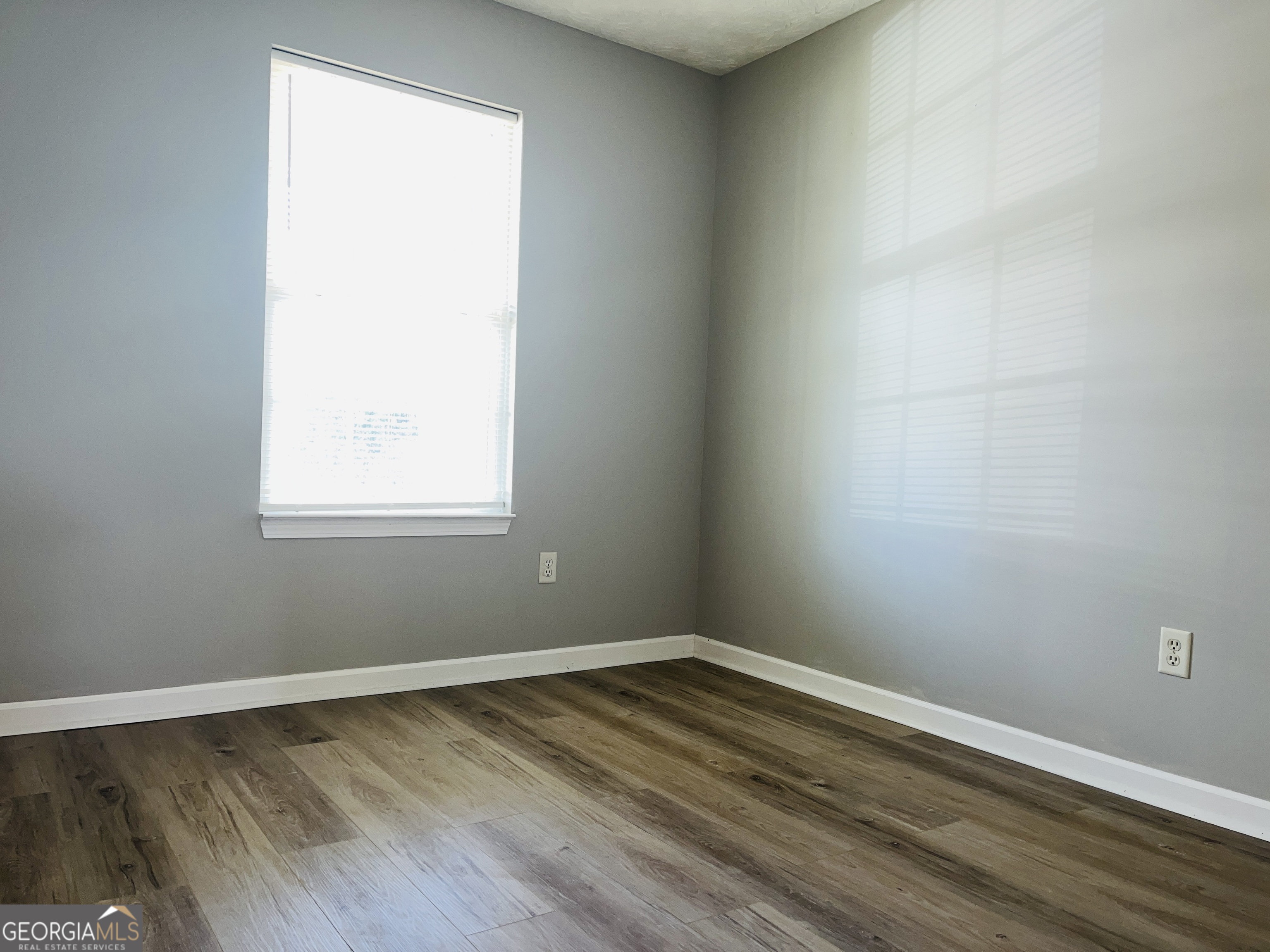 105 Granite Street, Unit B Hogansville, GA 30230 - Photo 16 of 28 an empty room with wooden floor and windows