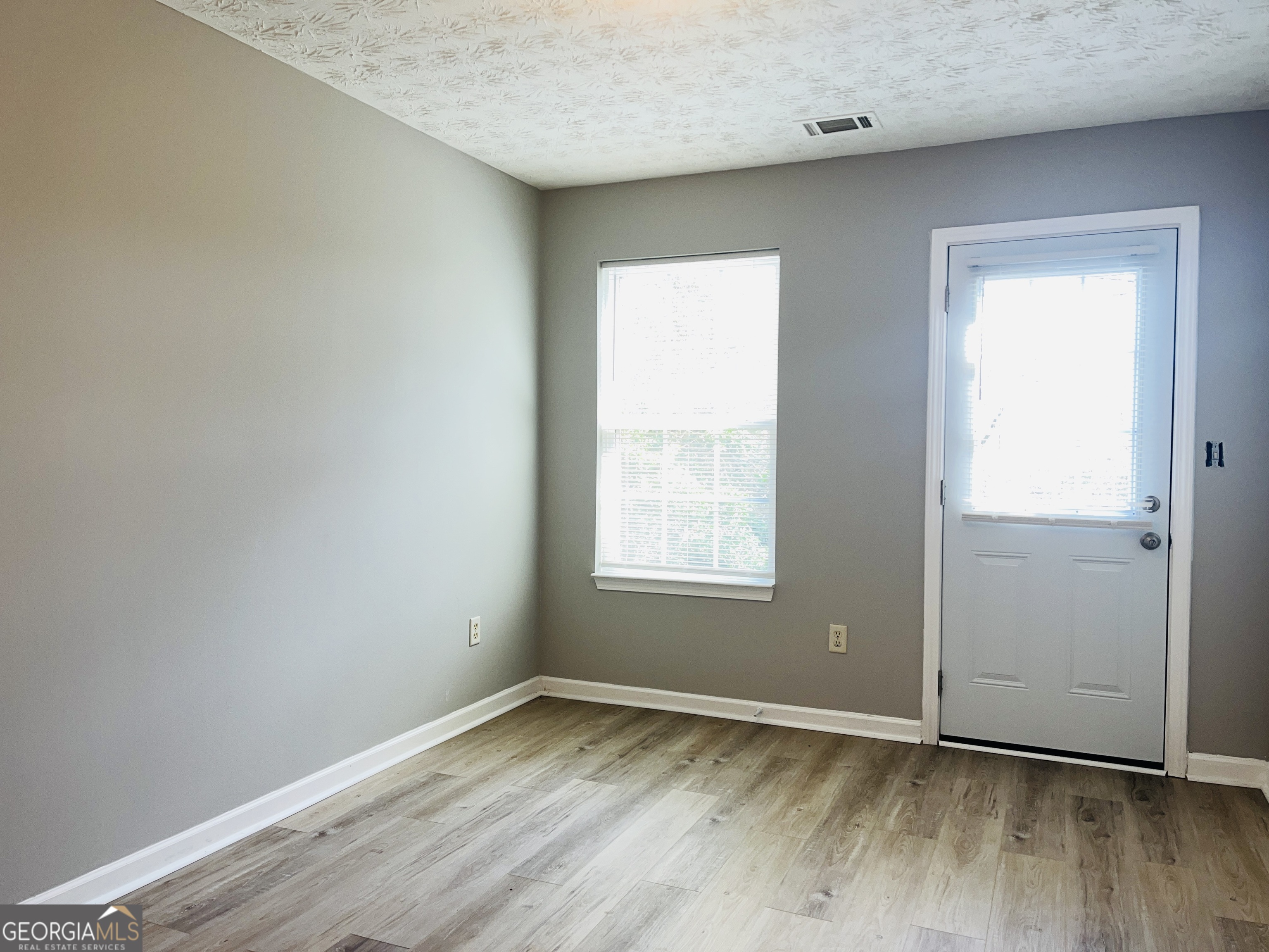 105 Granite Street, Unit B Hogansville, GA 30230 - Photo 19 of 28 an empty room with wooden floor and windows