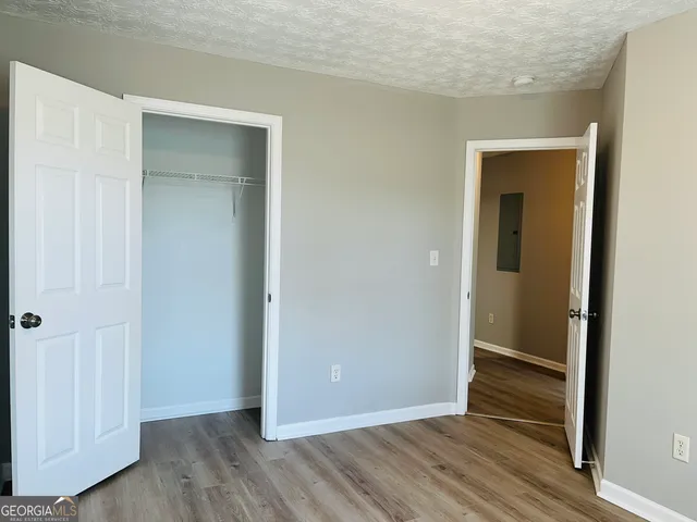 an empty room with wooden floor and closet