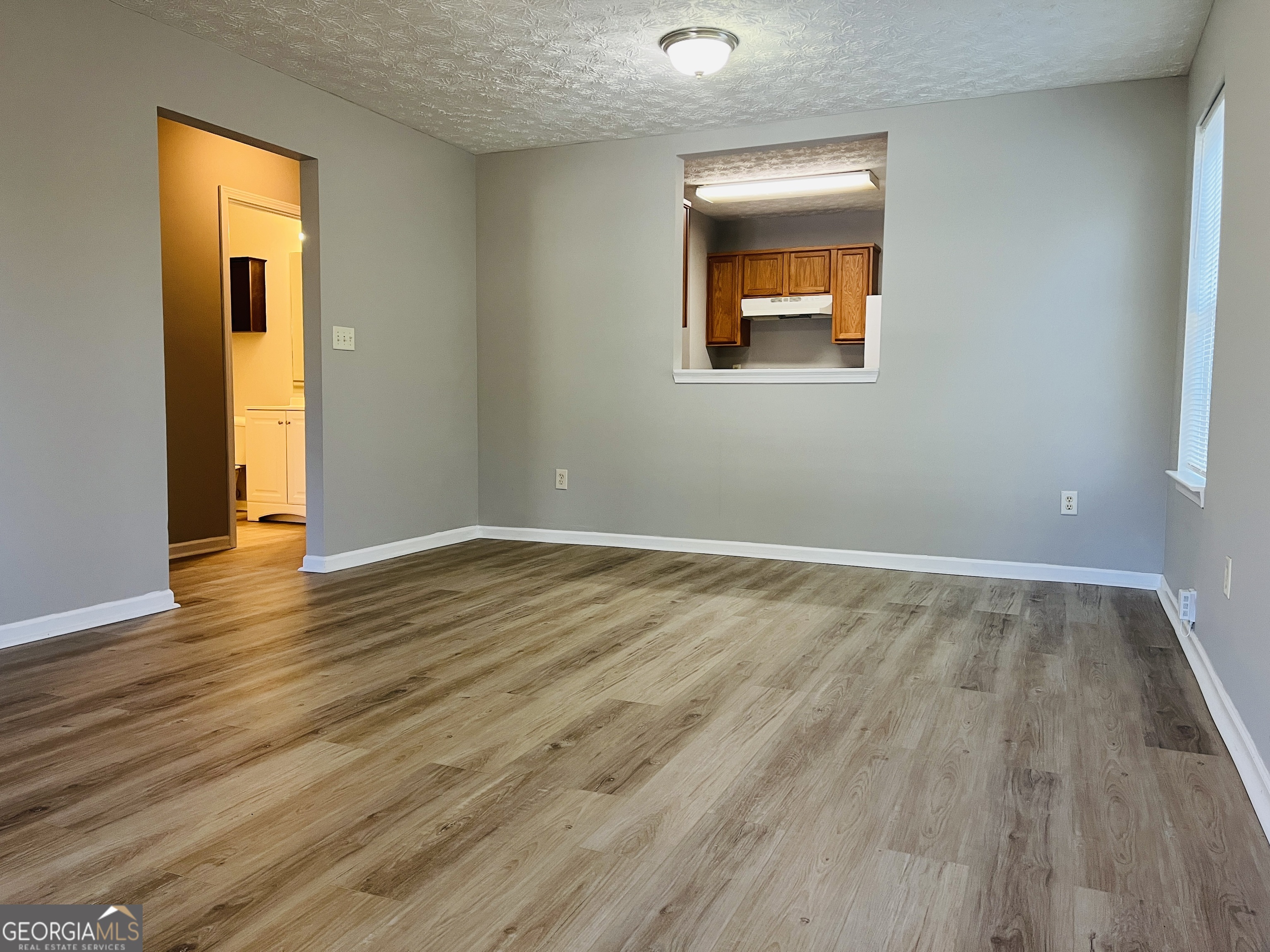 105 Granite Street, Unit B Hogansville, GA 30230 - Photo 7 of 28 a view of an empty room with wooden floor and a window