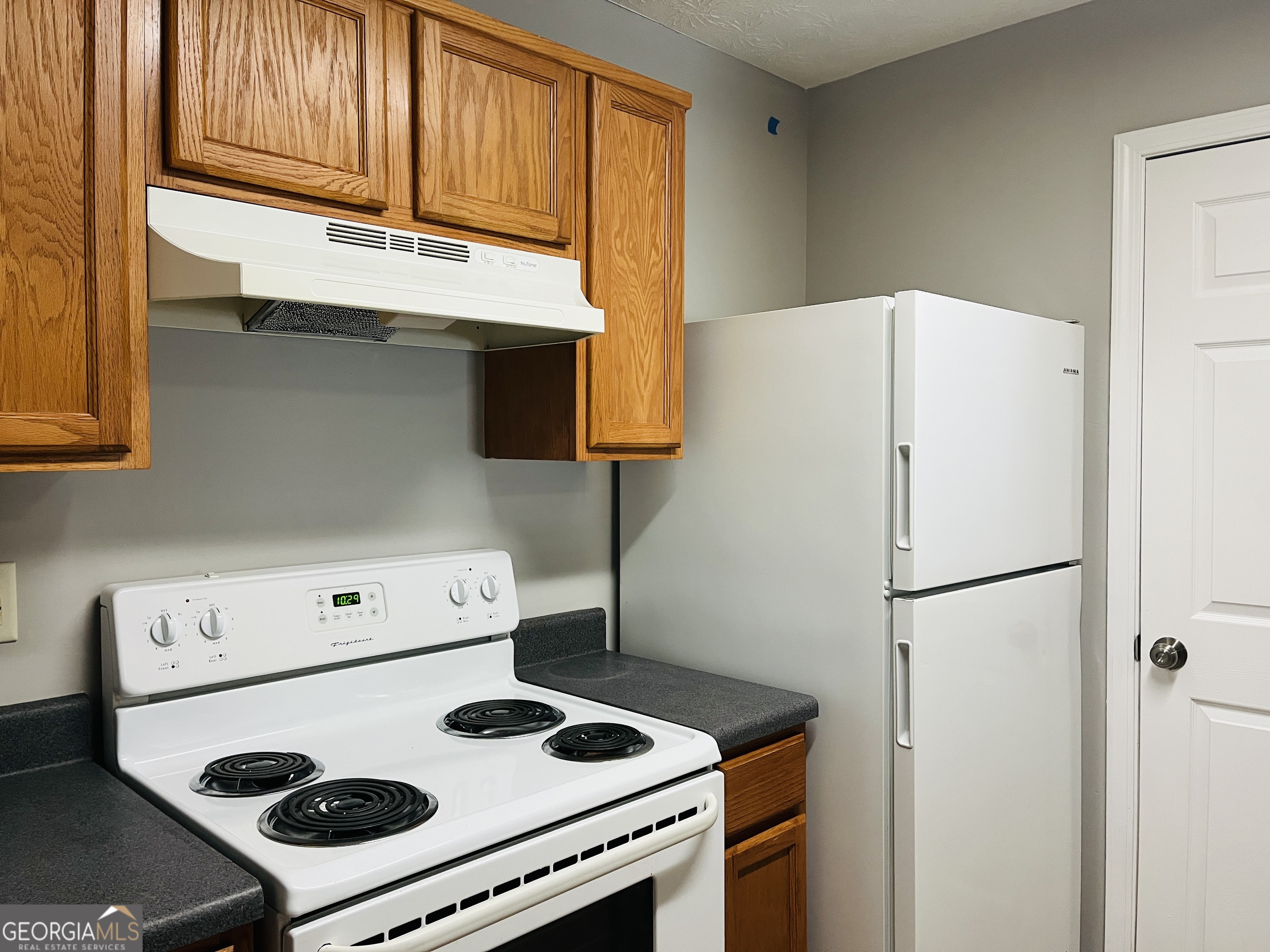 105 Granite Street, Unit B Hogansville, GA 30230 - Photo 9 of 28 a white refrigerator freezer and a stove sitting inside of a kitchen