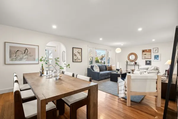 a view of a dining room with furniture a rug and wooden floor